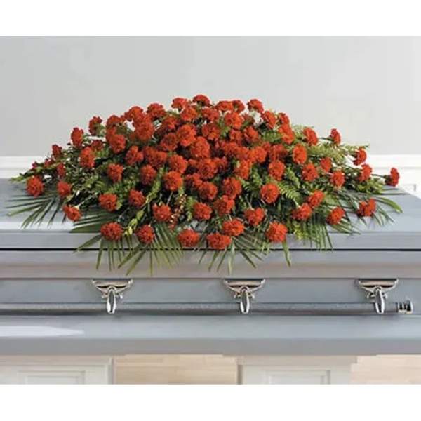 Red floral casket spray with greenery on a gray casket