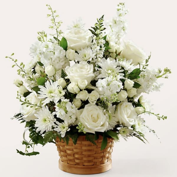 White roses and daisies arranged in a woven basket