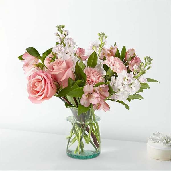 Pink roses and mixed pink-white flowers in a clear glass vase