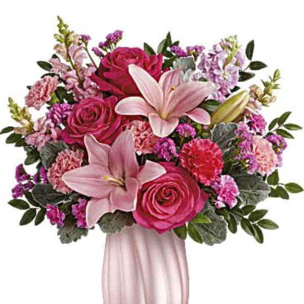 Pink roses and lilies arranged in a pink vase