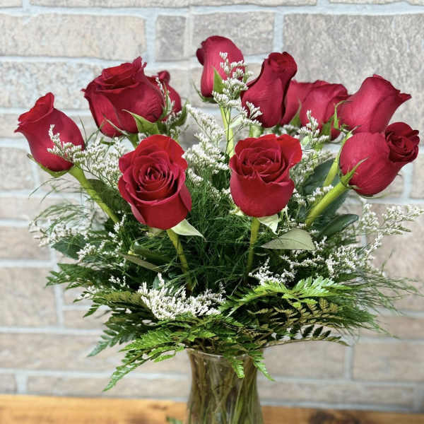 Red roses arranged in a clear glass vase