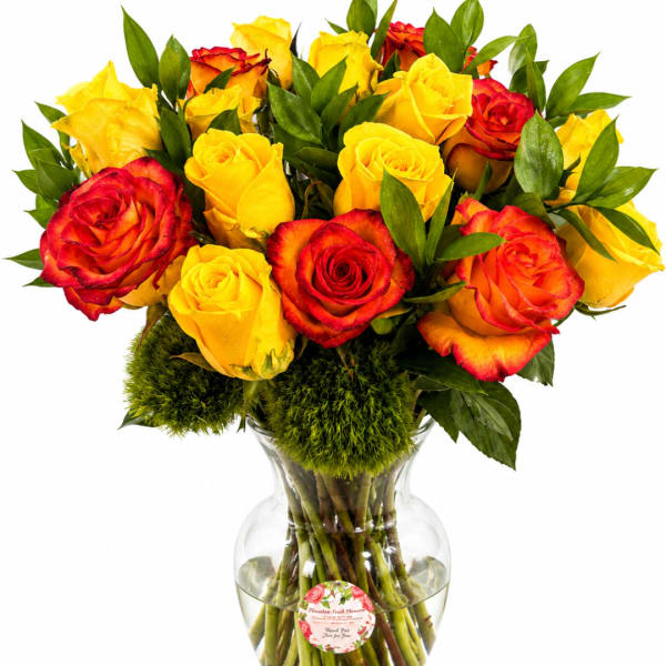 Bouquet of yellow and red roses in a clear glass vase