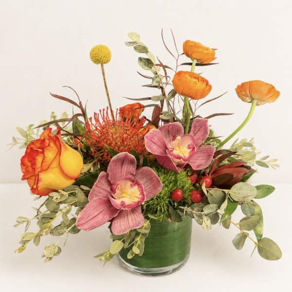 Orange and pink mixed bouquet in a glass vase