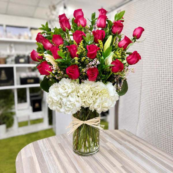 Bouquet of red roses and white hydrangeas in a glass vase
