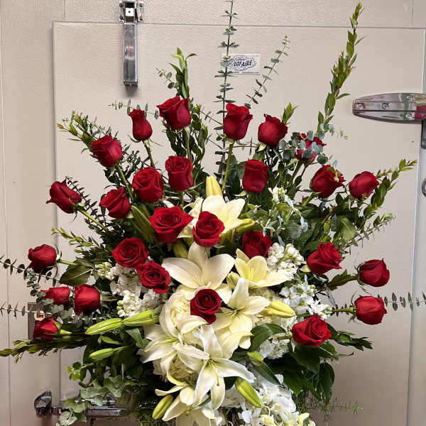Standing floral spray with red roses, white lilies, and white orchids
