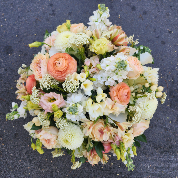Round bouquet of peach, cream, and white flowers