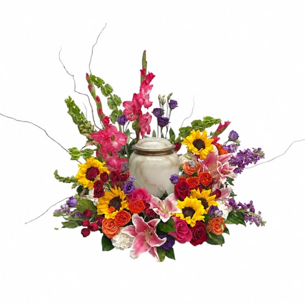 Colorful floral arrangement around a marble urn with sunflowers, roses, lilies, and orchids