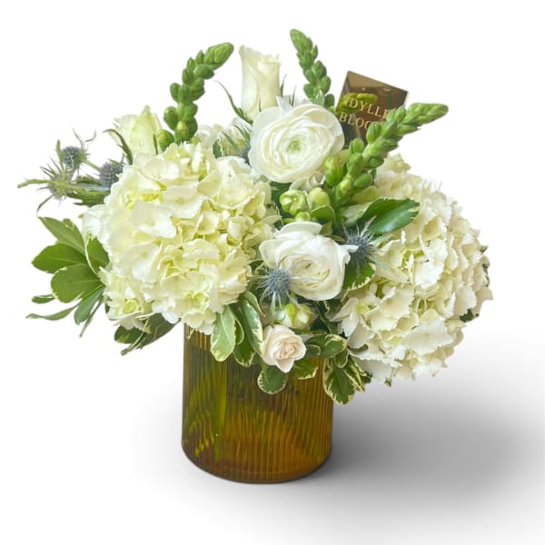 White floral arrangement in an amber glass vase