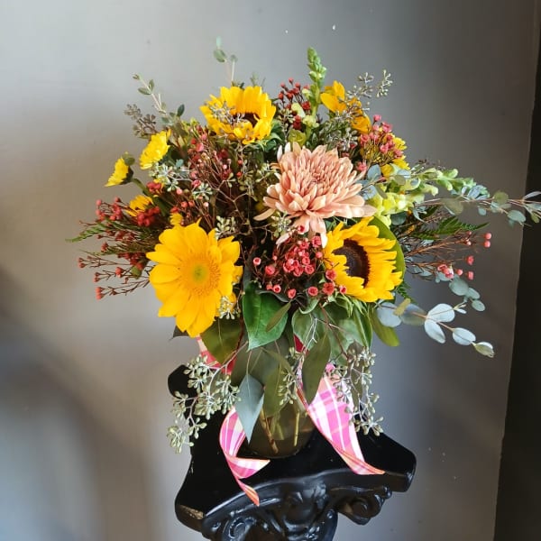 Mixed bouquet with sunflowers and a peach chrysanthemum in a vase