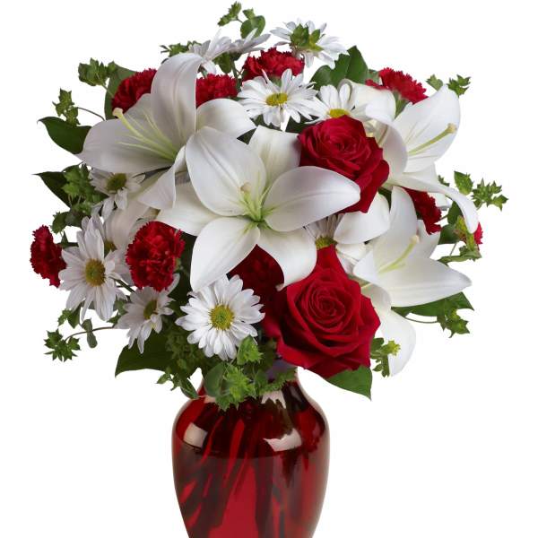 Bouquet of red roses, white lilies, and daisies in a red glass vase