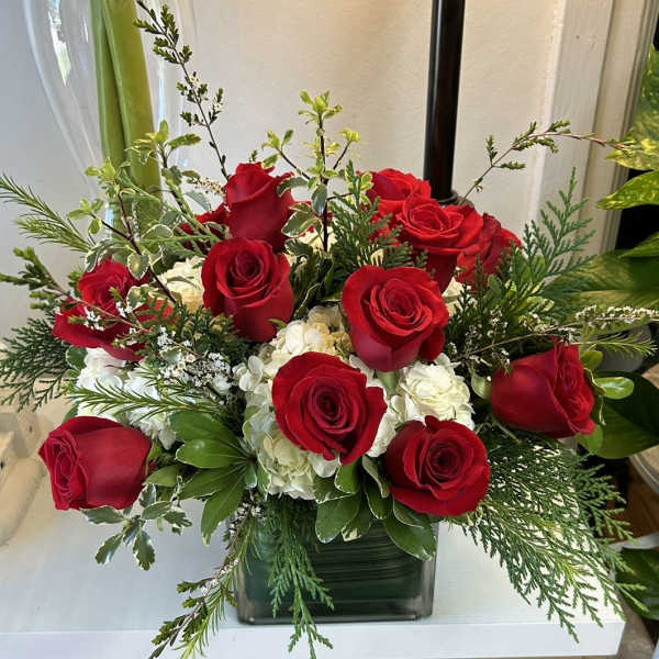 Red roses and white hydrangeas in a square glass vase