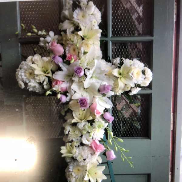 Cross-shaped floral spray with white lilies, daisies, and pink roses