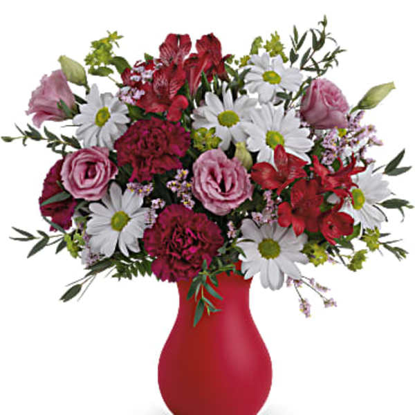 Mixed bouquet of pink and white flowers in a red vase