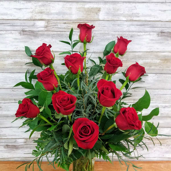 Red roses arranged in a clear glass vase
