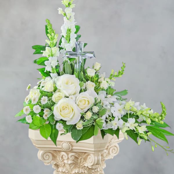 White rose and orchid arrangement with a clear cross centerpiece