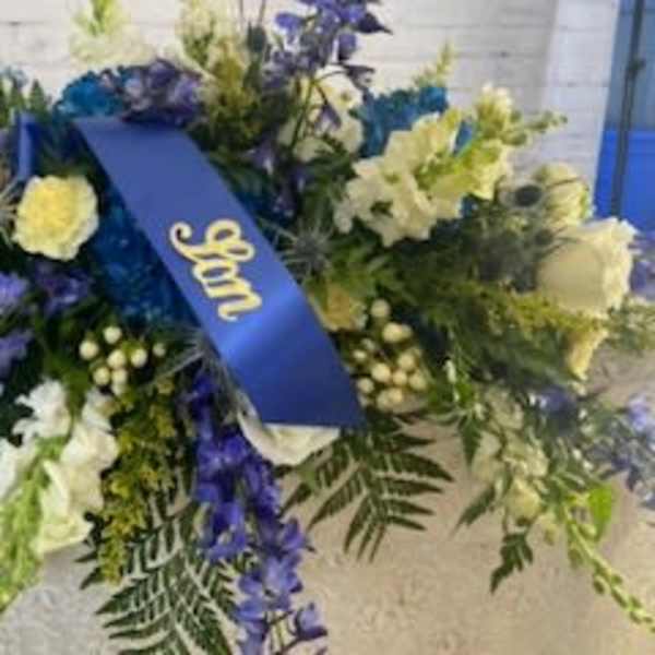Large blue and white floral spray with a ribbon