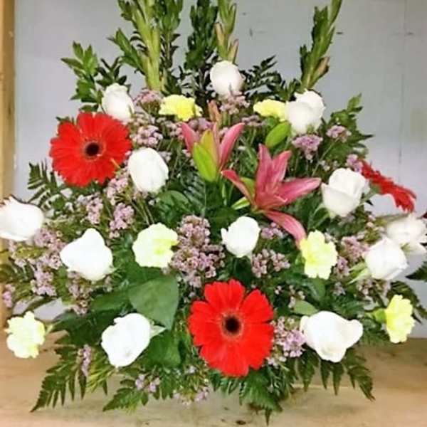 Large mixed floral arrangement with red gerberas, white roses, and pink lilies