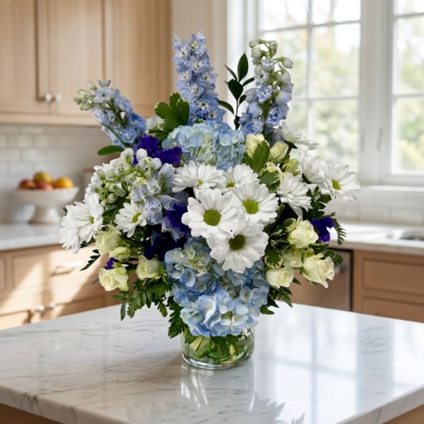 Blue and white mixed bouquet in a clear glass vase