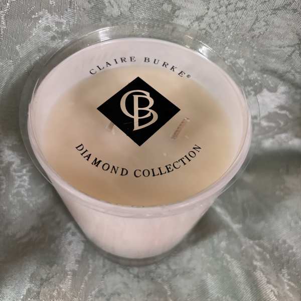 Pink candle in a clear plastic cup with a labeled lid