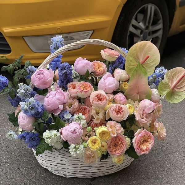 Large basket of pastel flowers with pink roses and blue blooms