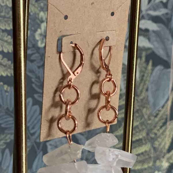 Pair of dangling earrings with rose-gold hoops and clear crystal drops