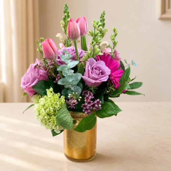 Pink and lavender bouquet in a gold vase with tulips and roses