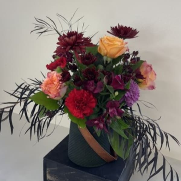 Mixed bouquet with roses and dark purple flowers in a vase