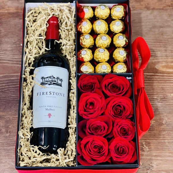 Gift box with a wine bottle, chocolates, and red roses