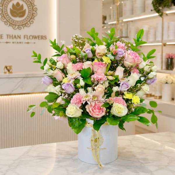 Pastel rose bouquet in a white hatbox with a ribbon