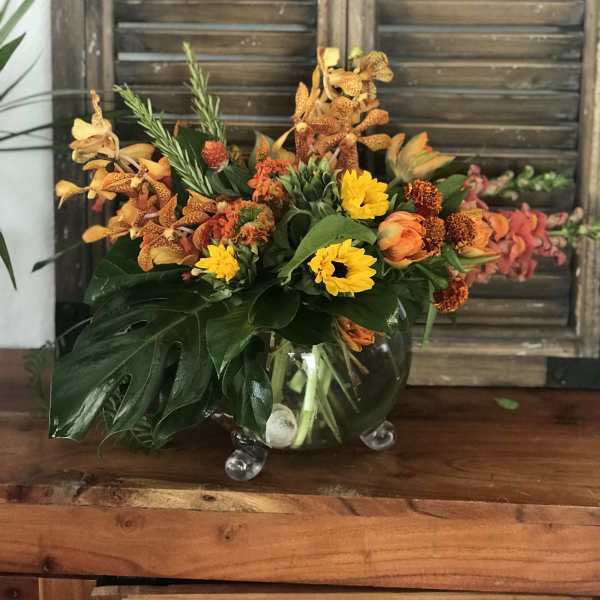 Orange and yellow floral arrangement in a clear glass vase