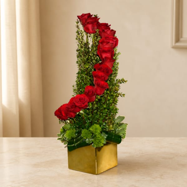 Tall red rose arrangement in a gold square vase