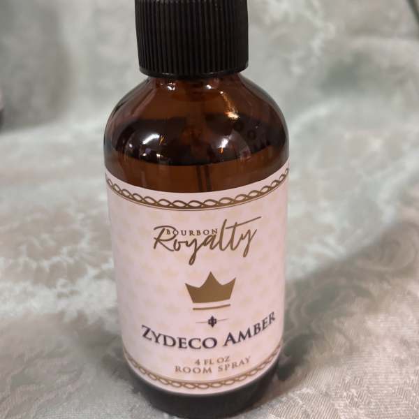 Amber room spray bottle with a pink label and black spray top