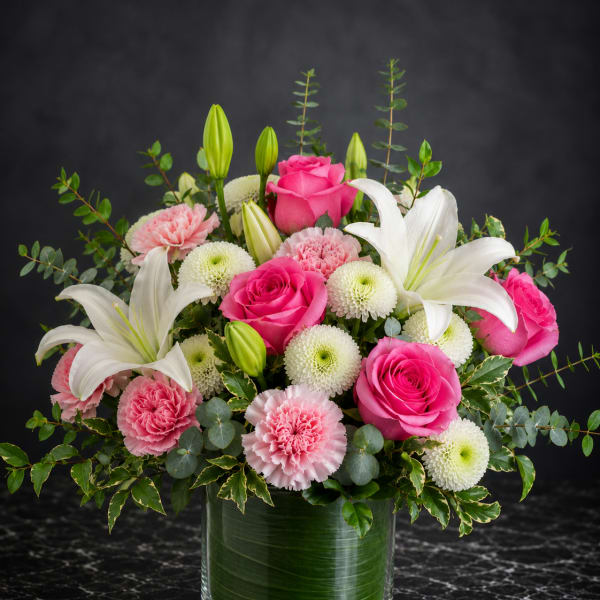 Pink roses and white lilies arranged in a glass vase