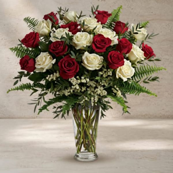 Red and white roses arranged in a clear glass vase