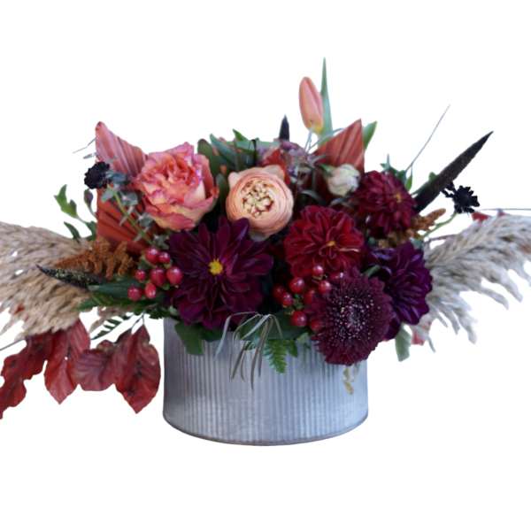 Autumn floral arrangement in a ribbed metal container with burgundy and peach blooms