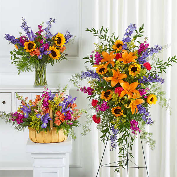 Bright mixed flower arrangements with sunflowers and lilies in a vase and basket.