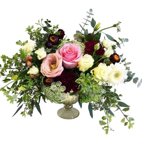 Wedding bouquet with pink, cream, and burgundy flowers in a glass compote vase