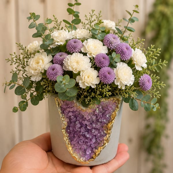 Small bouquet of white and lavender flowers in a decorated pot