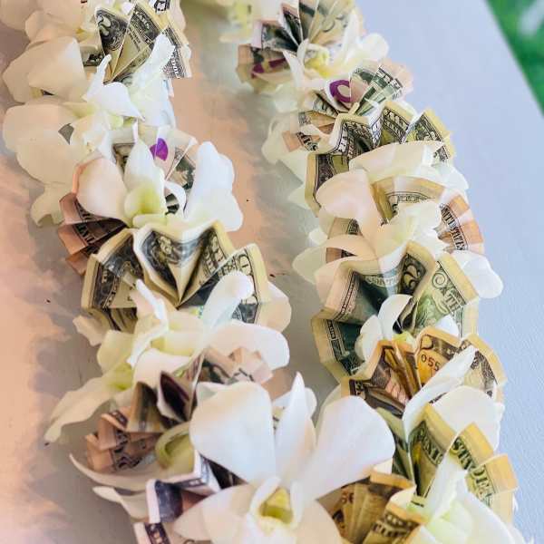 White flower garland with folded dollar bills woven into each bloom
