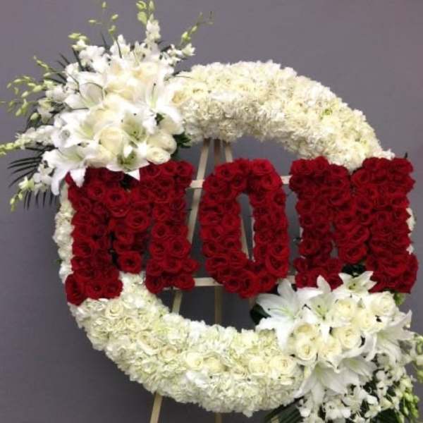 Large floral standing wreath with red and white flowers on an easel