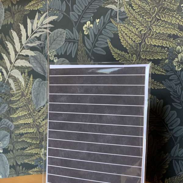 Blank striped card in a clear sleeve on a wooden table