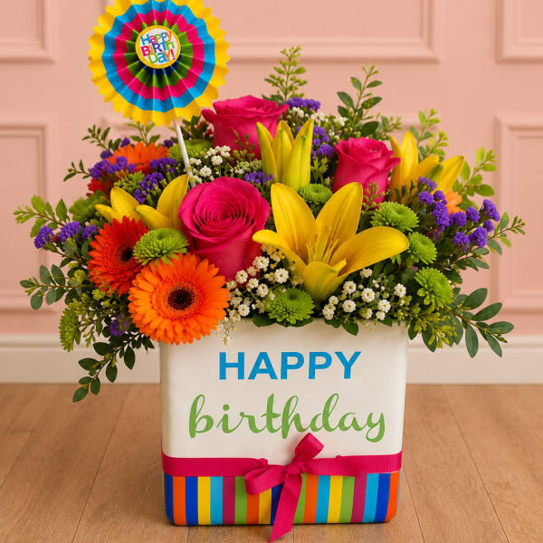 Birthday flower arrangement in a striped gift box with a colorful topper
