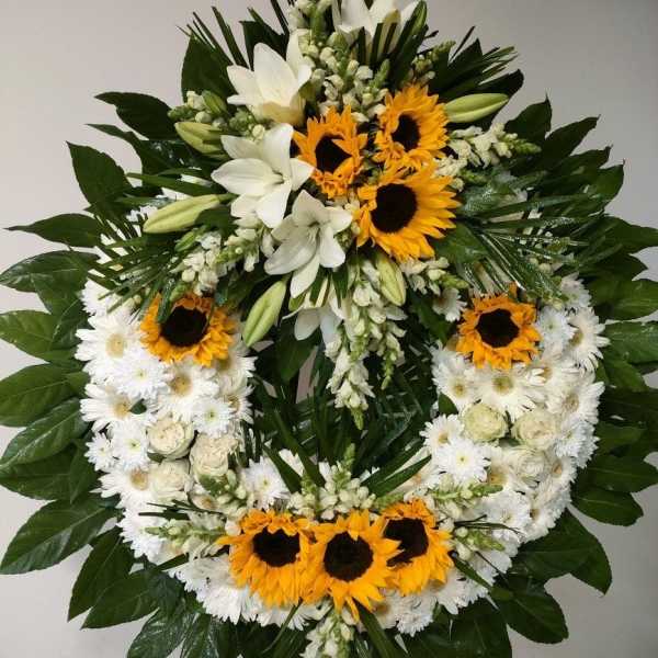 Circular floral wreath with white flowers and yellow sunflowers
