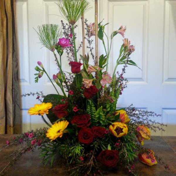 Tall mixed floral arrangement with red roses and yellow gerbera daisies