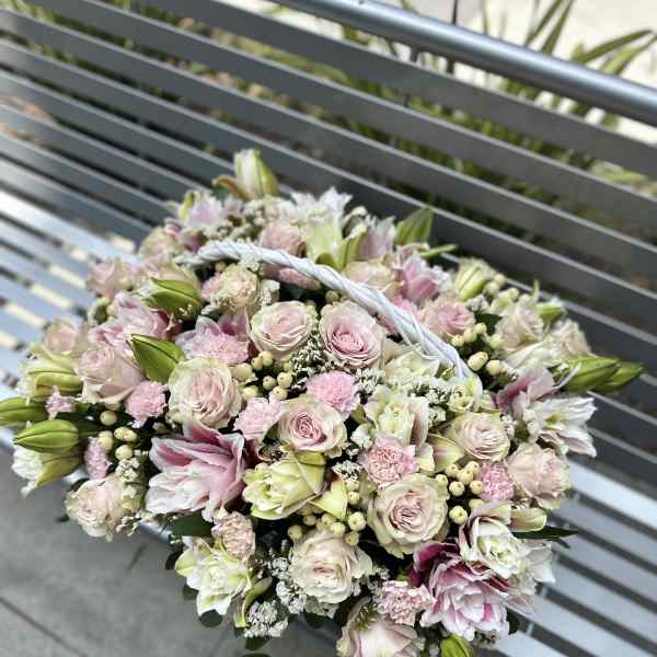 Handheld bouquet of pale pink and white flowers with a braided handle