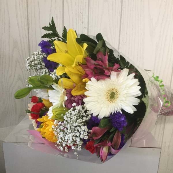 Mixed bouquet with yellow lilies, white gerbera daisies, and purple accents