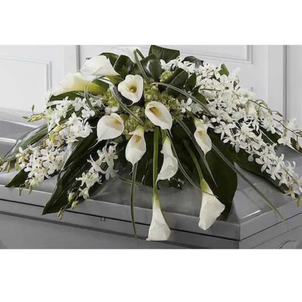 White calla lilies and orchids arranged on a casket