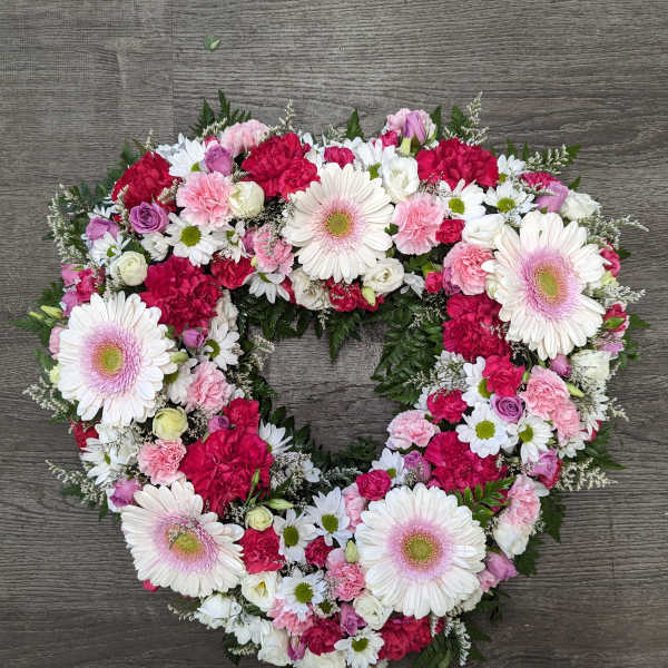 Heart-shaped floral wreath with pink, white, and red blooms