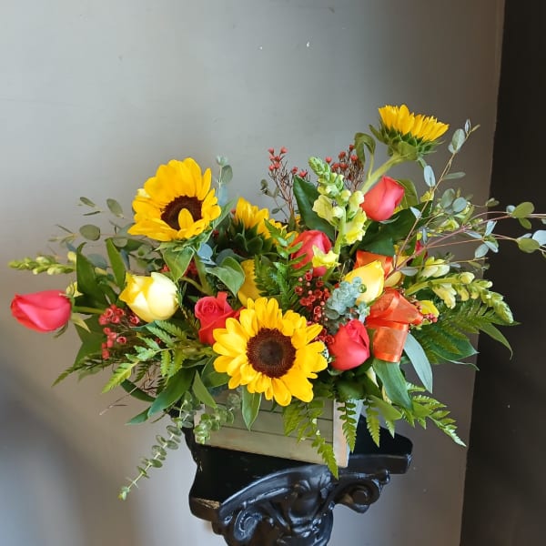 Mixed bouquet with sunflowers and roses in a wooden box