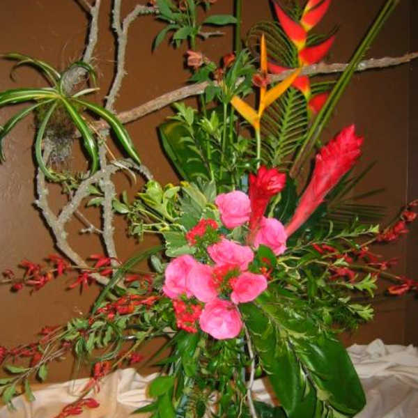 Tall tropical floral arrangement with pink blooms and red-orange heliconia